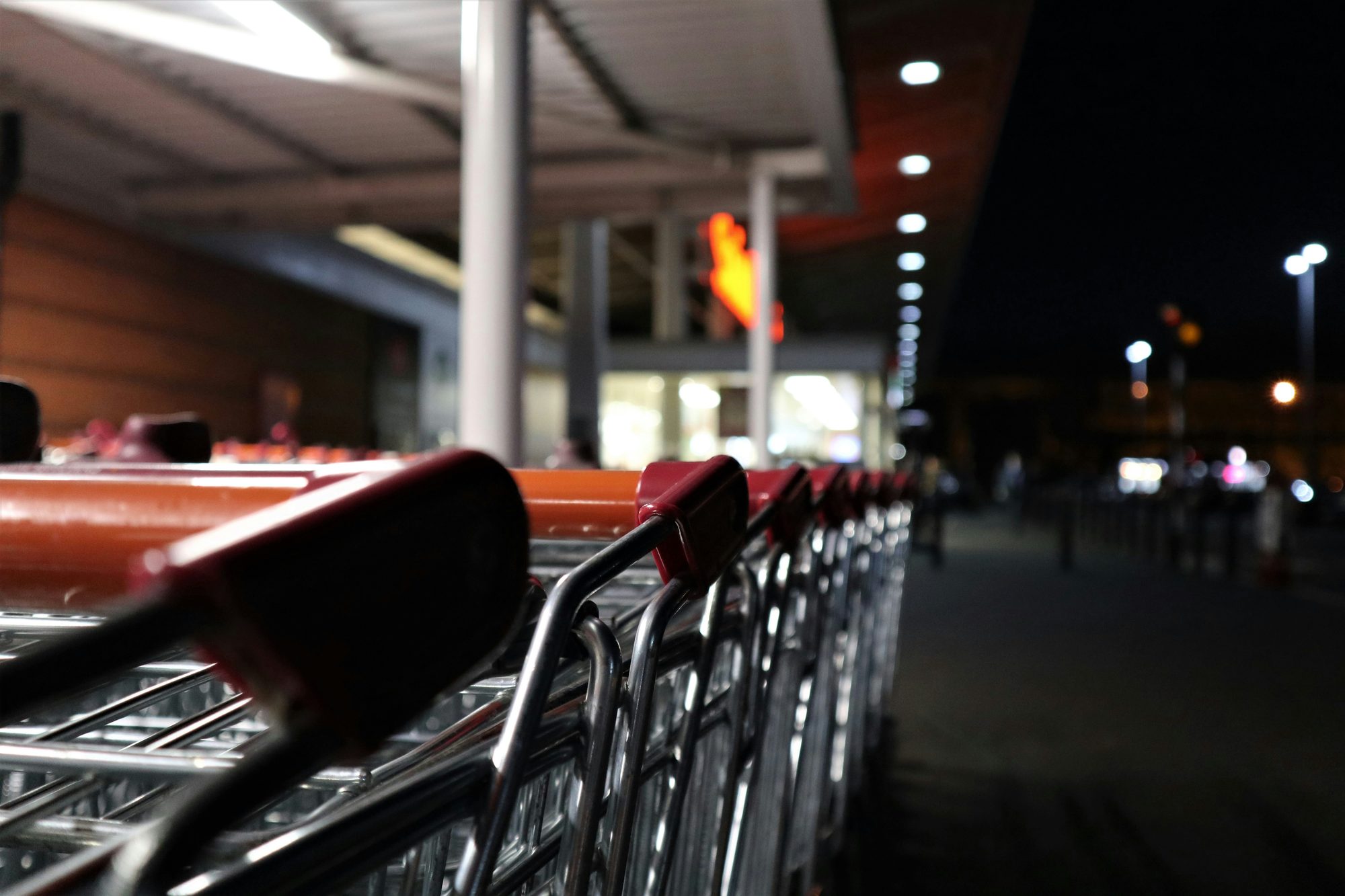 A station platform at night with a train pulling away, missed by minutes