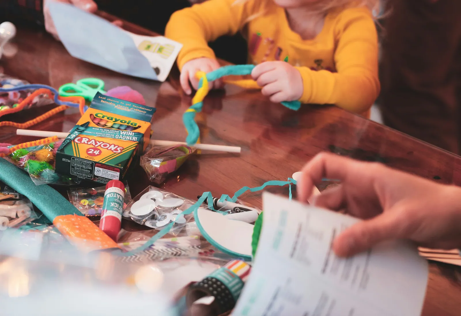 A busy desk of pens, crayons and school supplies mid-use